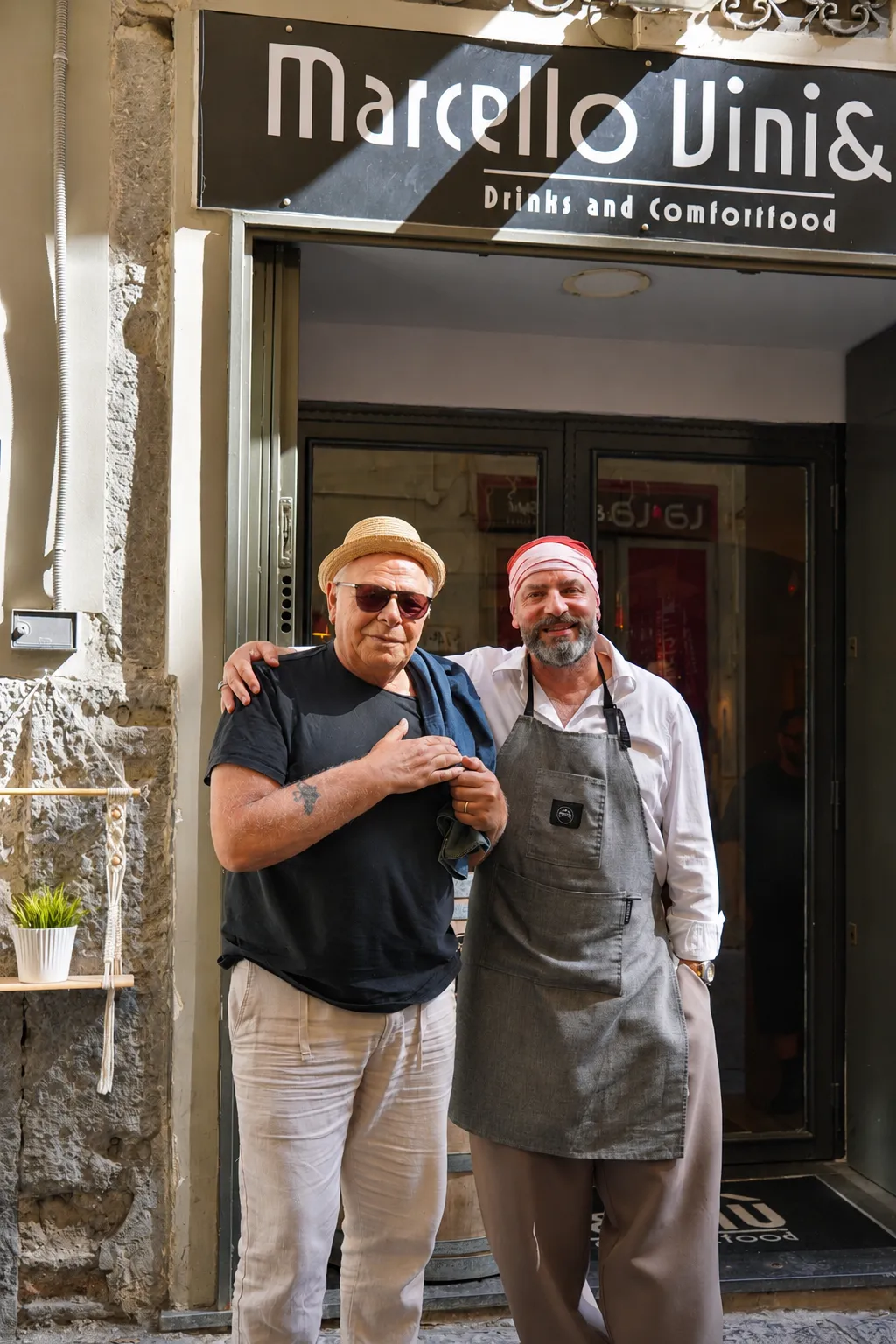 Marcello con un cliente davanti all’insegna del locale a Chiaia