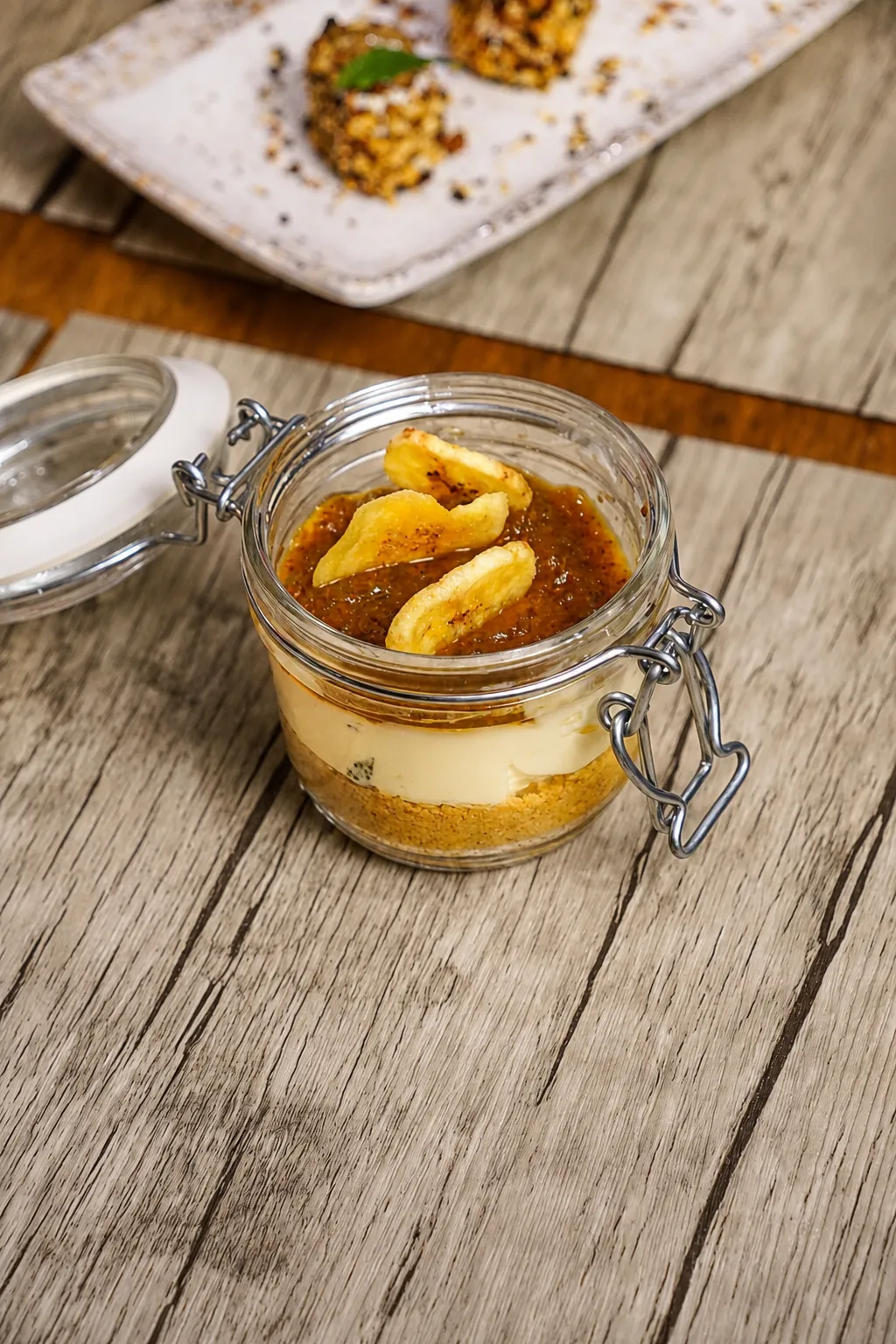 Cheesecake artigianale servita nel vasetto con topping e chips di banana